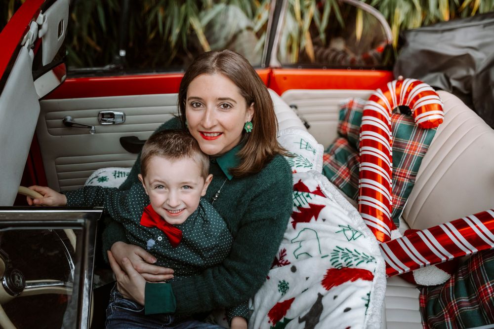 Mini-session photo de Noël 2024 avec une coccinelle VW rouge décorée pour les fêtes, créant une ambiance festive et chaleureuse.