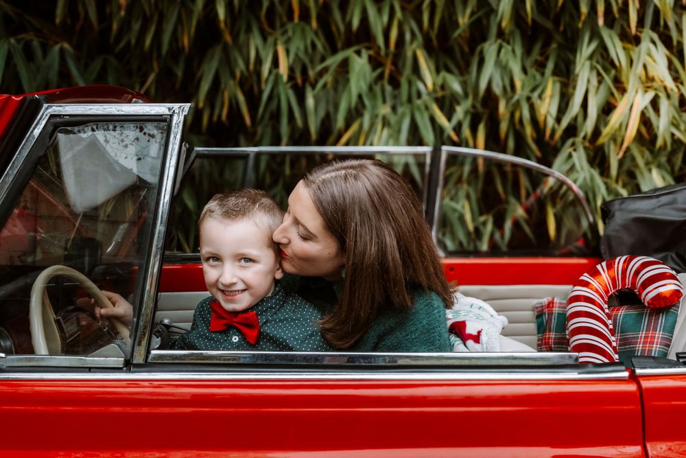 Mini-session photo de Noël 2024 avec une coccinelle VW rouge décorée pour les fêtes, créant une ambiance festive et chaleureuse.