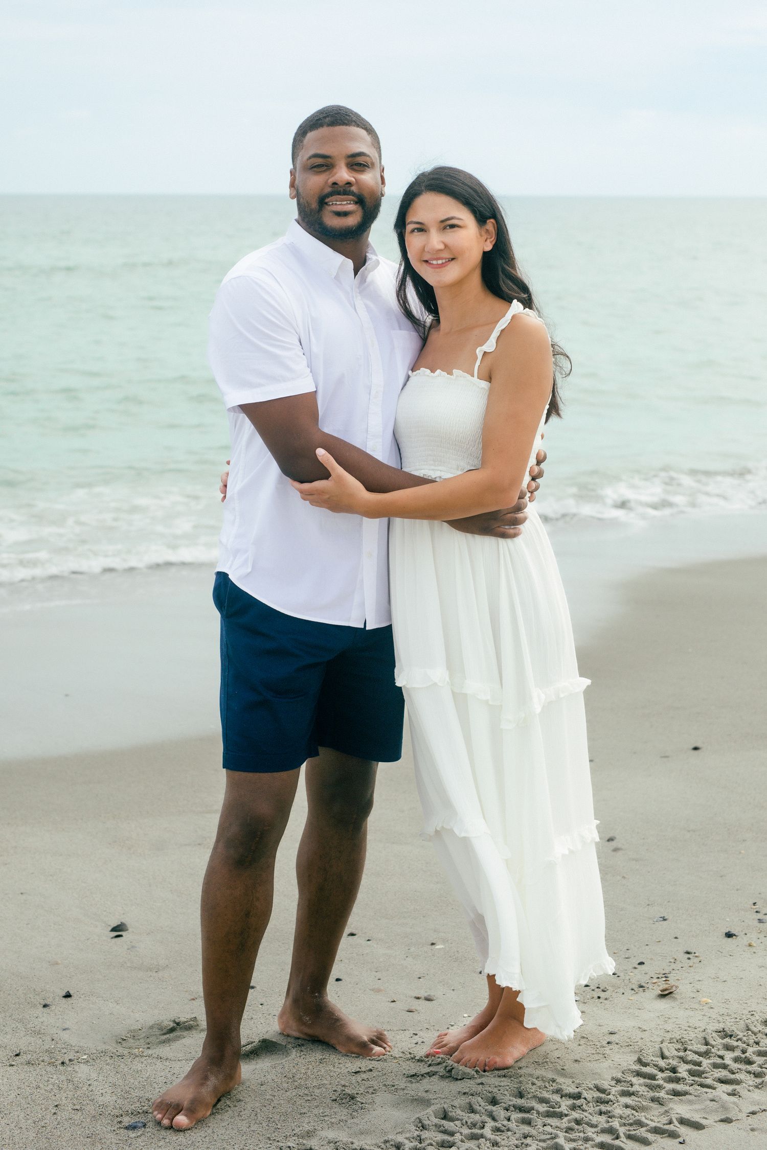 Outdoor couple’s portrait with sand and water on the beach and soft natural tones in Essex County captured by Tasha Cannaday.