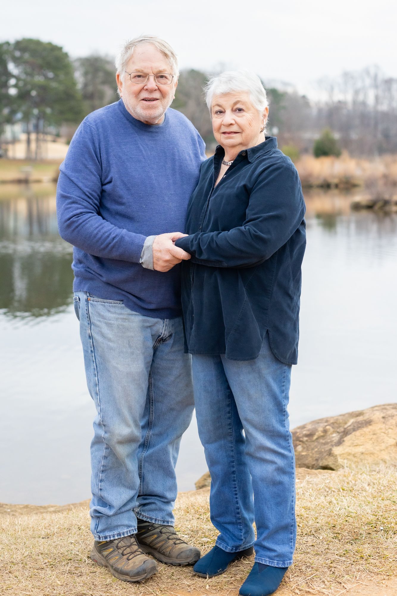 Smiling older couple holding hands during a golden hour photo session in Windsor, Ontario.