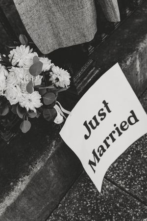 A series of black and white photographs showing handwritten name cards with white flowers against a dark background.