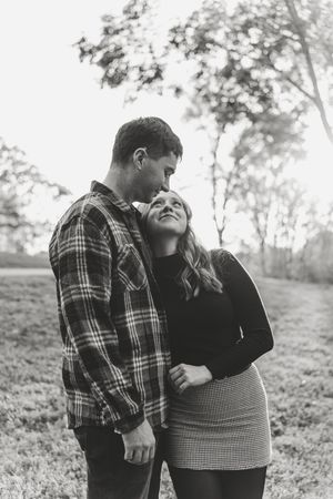 Black and white photo series showing couple in plaid flannel and dark clothing embracing outdoors in nature setting.