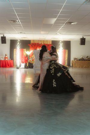 Large empty dance studio with gray floor and red curtain decorations hanging on the walls.