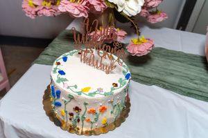A collage of five decorated birthday cakes with colorful frosting, sprinkles and candles on display.