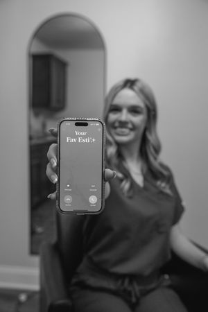A black and white photo showing someone holding up a smartphone displaying text on its screen.