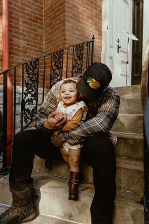 A heartwarming moment between parent and child sitting on brick steps.