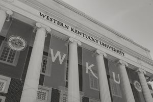 Black and white photo of Western Kentucky University's iconic columned building facade with WKU banners.