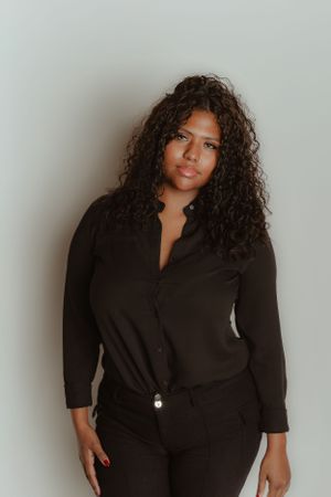 Studio portrait against white background wearing black button-up shirt.