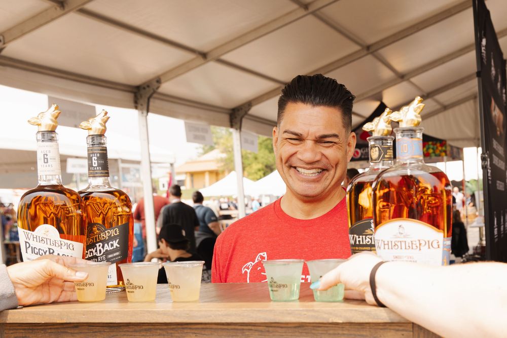 Food truck vendors serving customers at an outdoor event.