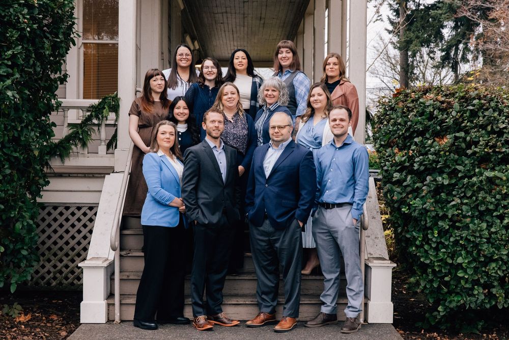 Group of professional real estate team members posing on outdoor steps.