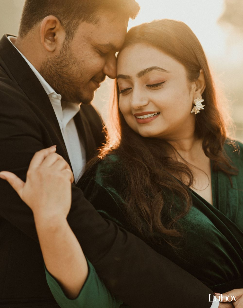 Romantic couple in formal wear sharing intimate moment during golden hour portrait session.