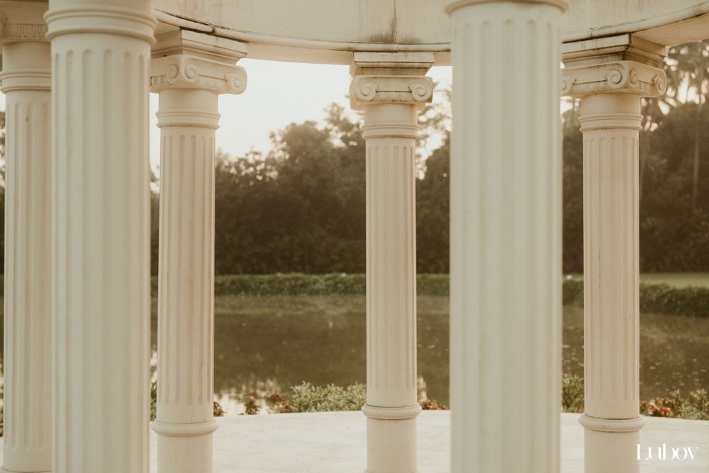 Classical white pillared gazebo architecture with Corinthian columns in outdoor setting.