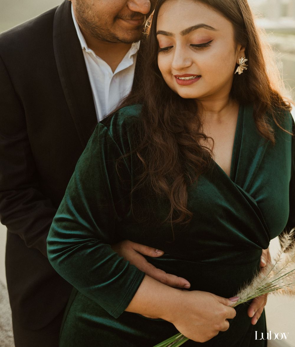 Intimate moment captured in emerald velvet dress with pampas grass during golden hour.
