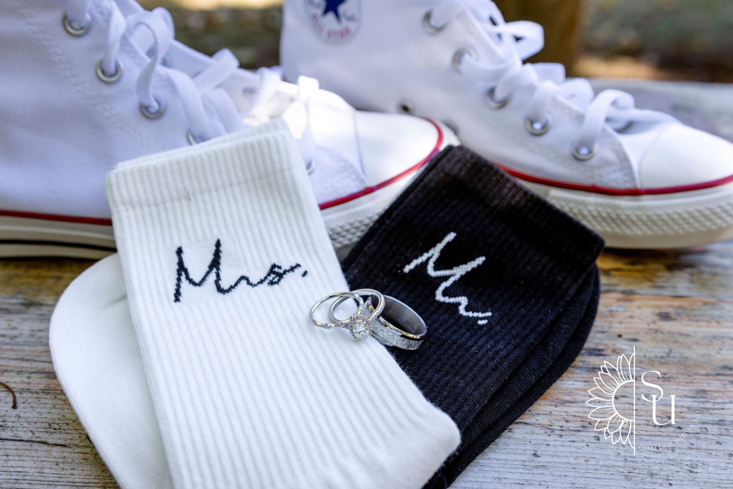 Wedding socks labeled Mr and Mrs with rings on white Converse sneakers.