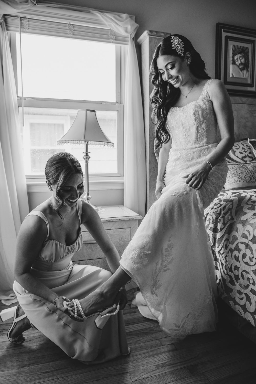Black and white photos showing wedding dress fitting and adjustments near a window.