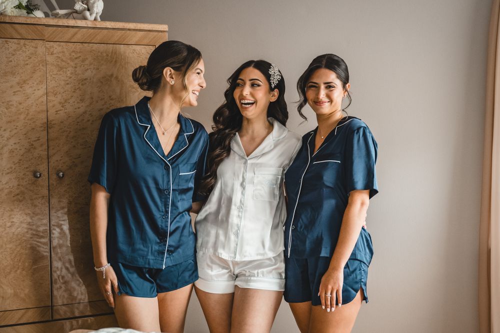 Group wearing coordinated blue and white outfits in casual wedding preparation setting.