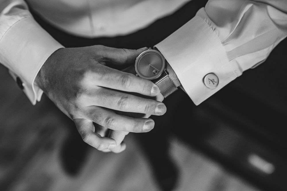 Close up black and white shot of hands adjusting formal wear accessories.