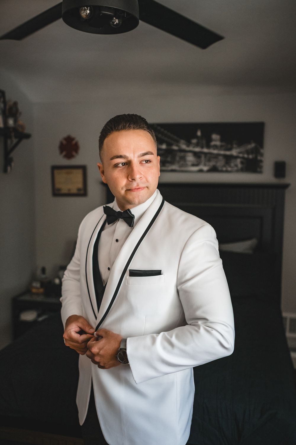 Multiple views of someone in a white tuxedo jacket with black trim preparing for a formal event.