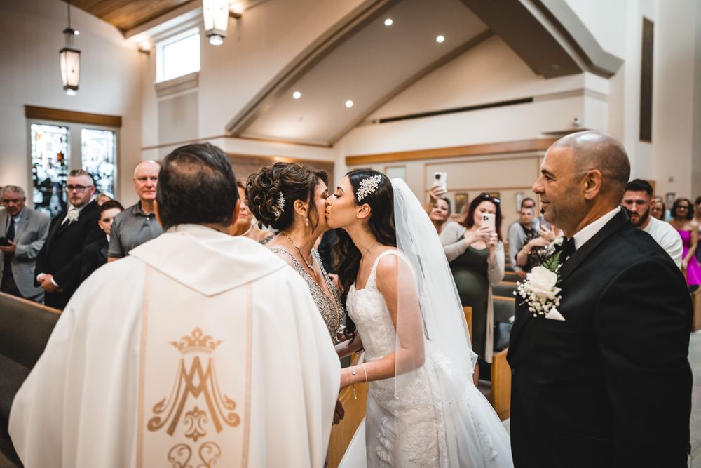 Interior of modern church during wedding ceremony with wooden beams and elegant lighting.