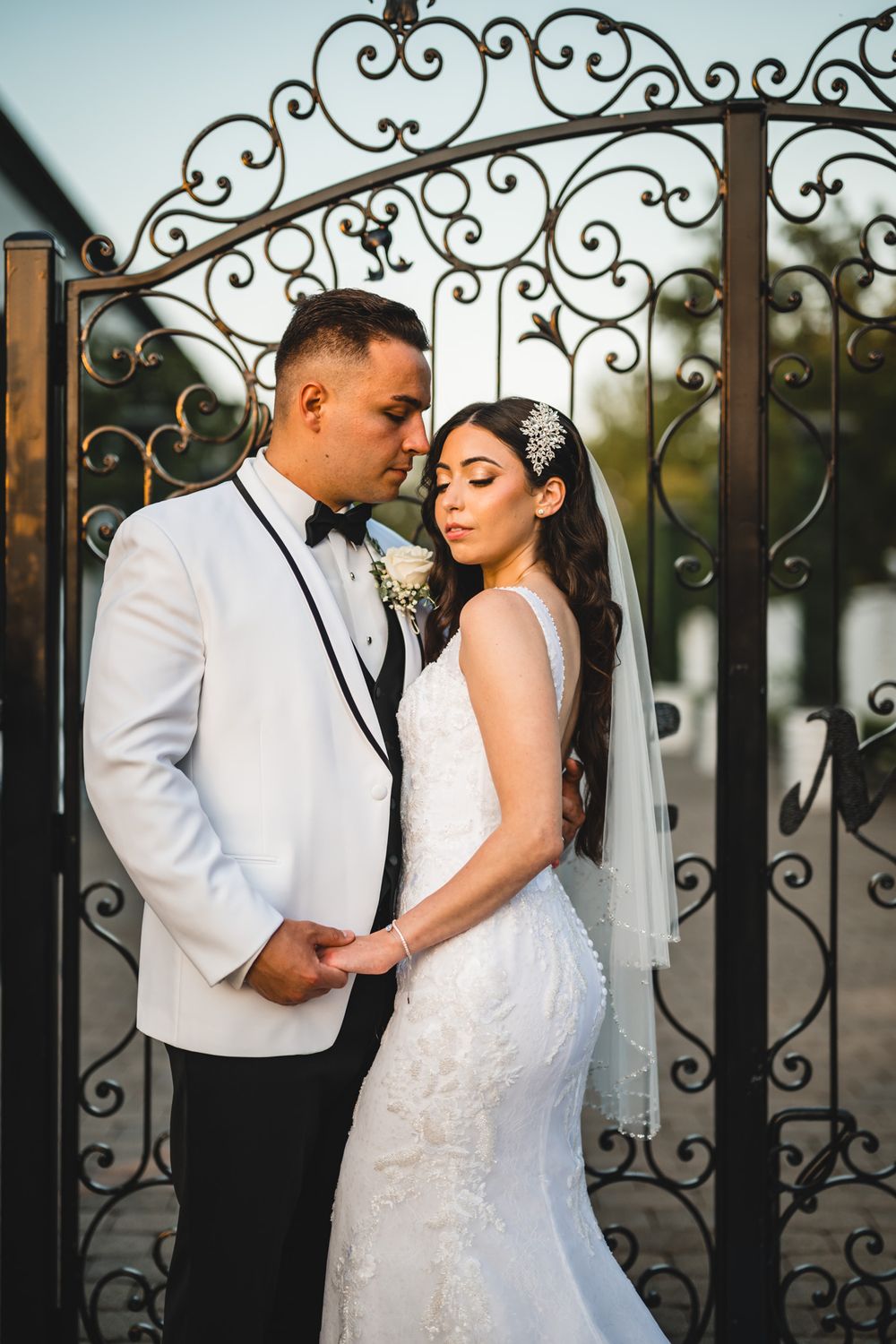 Romantic wedding portraits captured against an ornate wrought iron gate.