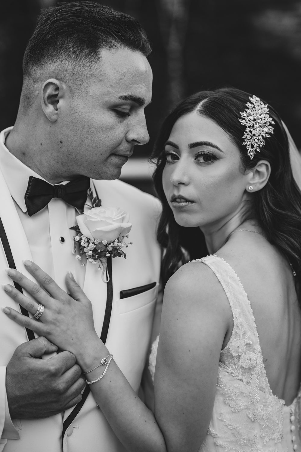 Black and white intimate portrait of newlyweds sharing romantic moment.