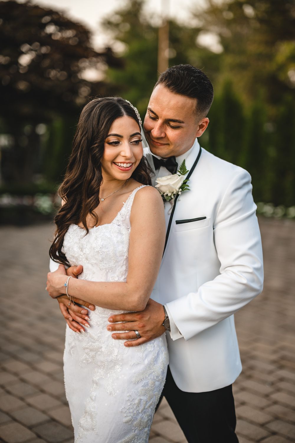 Romantic sunset portraits of newlyweds embracing on stone patio.