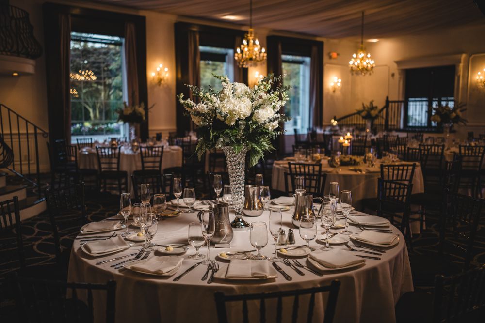 Moody reception venue with elegant table settings and ambient lighting.