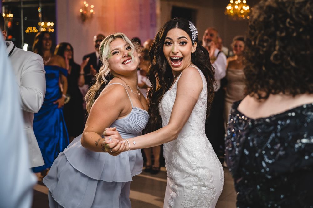 Candid moments of wedding guests dancing and laughing during an evening reception celebration.