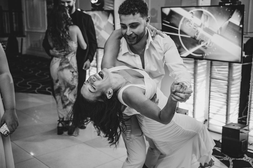 Energetic dance floor scene with wedding guests celebrating in formal attire.