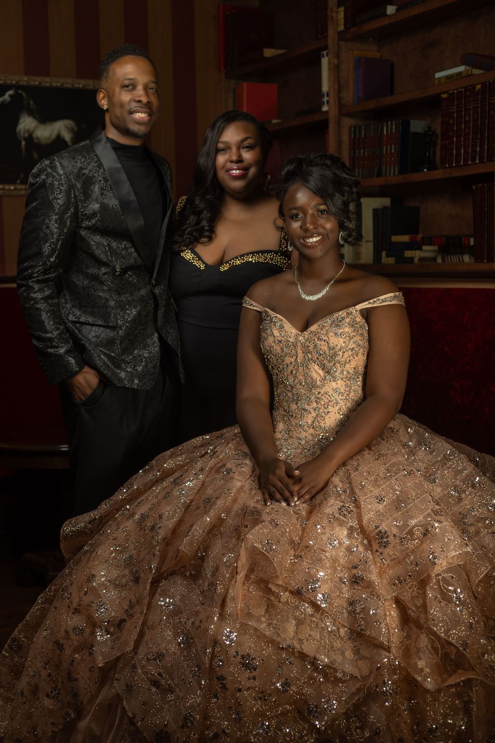 A couple poses together at a formal event, with the person wearing a sparkling champagne-colored ball gown.