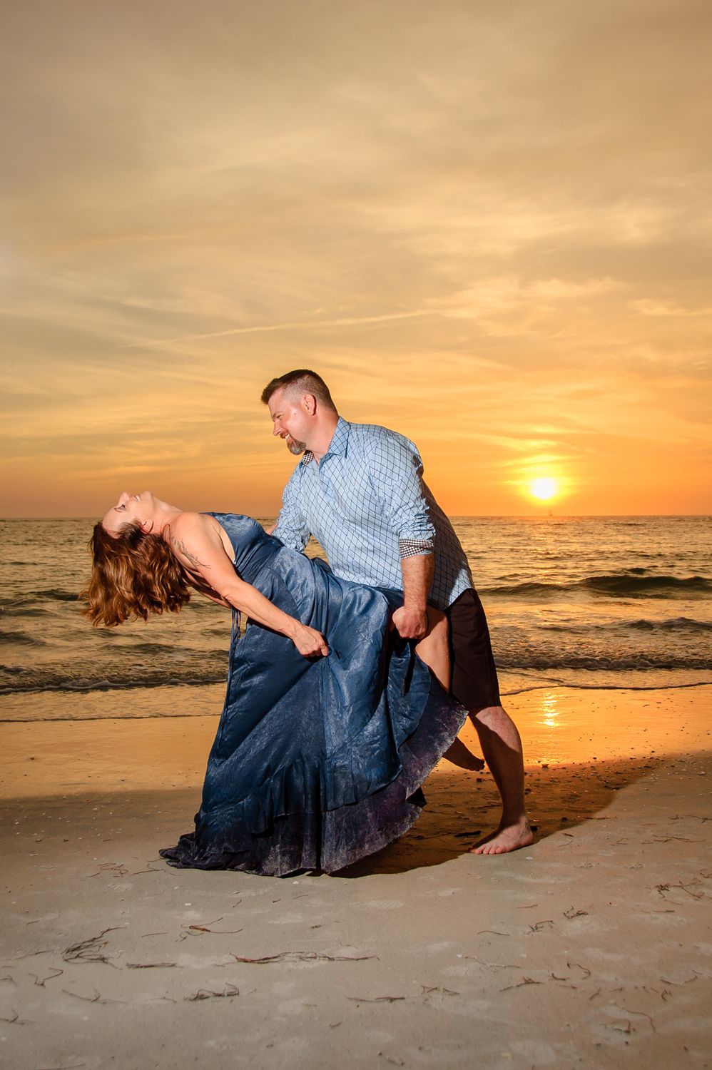 photo of man dipping woman during sunset in new port richey
