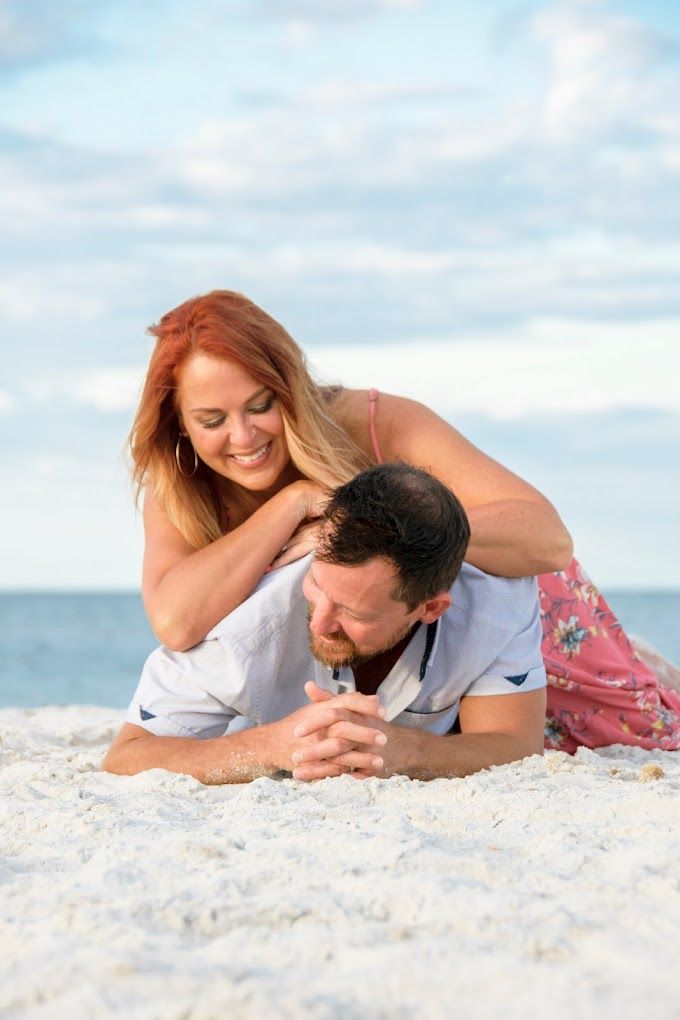 engagement photo of couple lying on the beach in New Port Richey