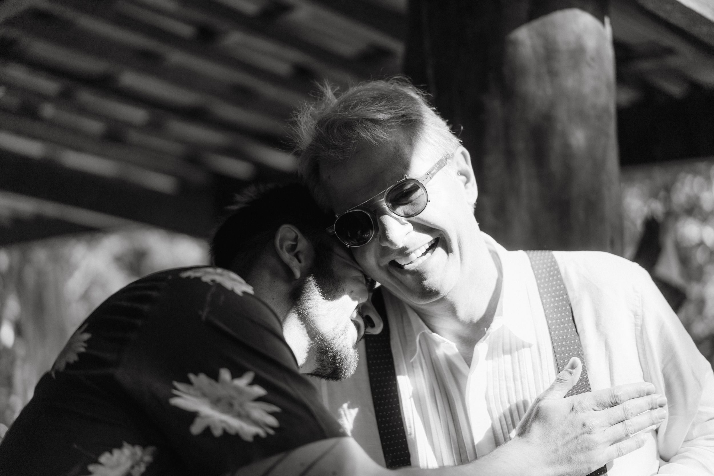 Candid wedding moments captured in black and white with emotional embrace.
