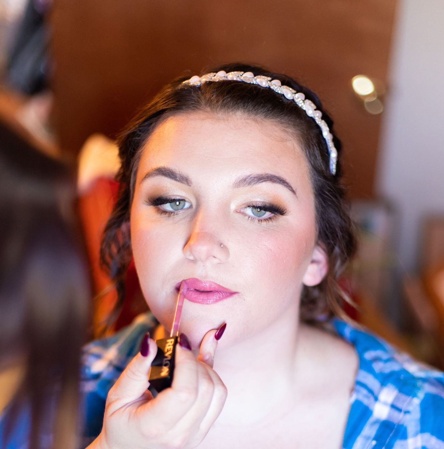 Close-up shots of makeup being applied during wedding preparation.