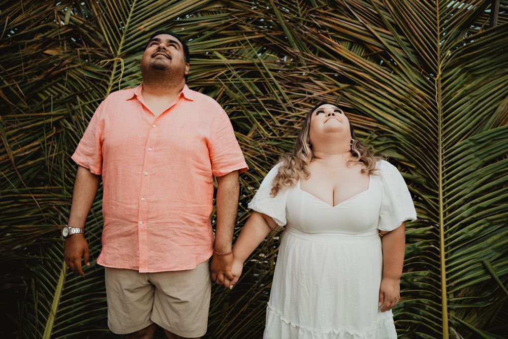 ooking at the sky, holding hands, palm trees background