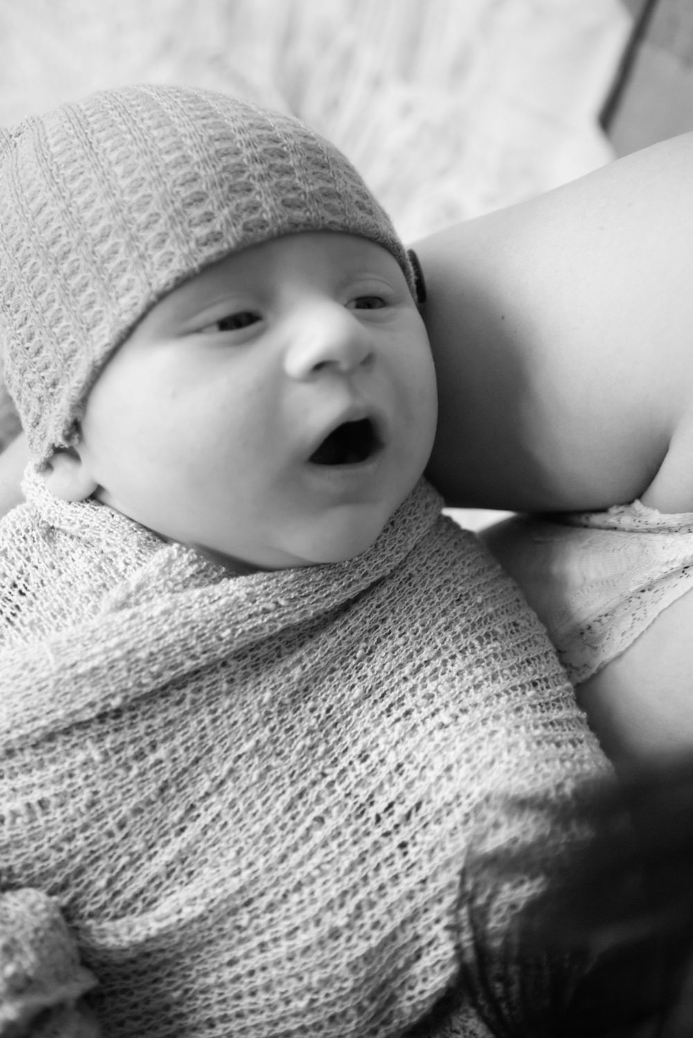A series of profile views showing a baby dressed in a knit hat lying on white fabric creating a sweet progression.