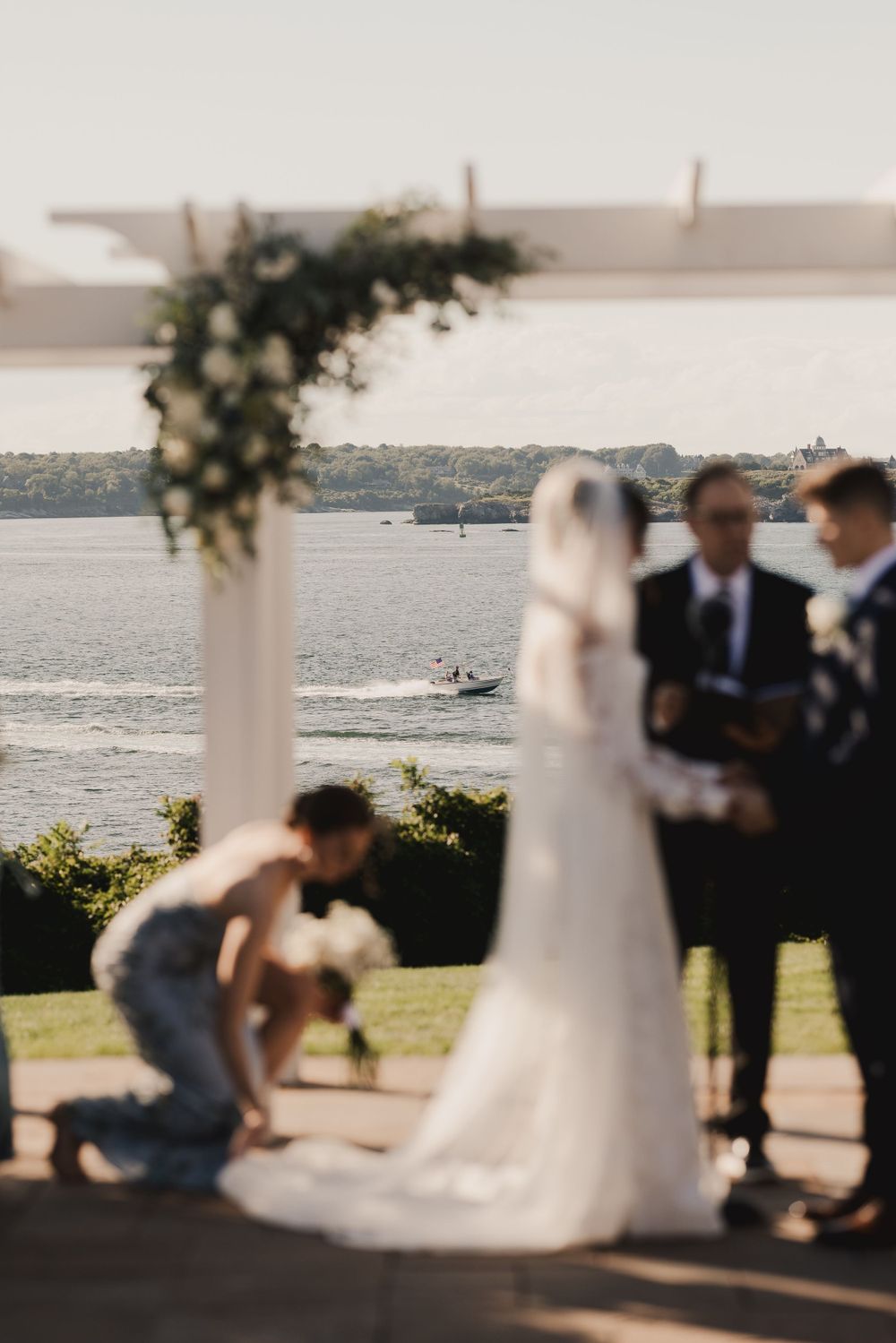 A waterfront wedding ceremony with scenic ocean views and decorative floral arch.