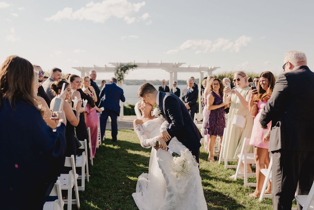Wedding ceremony recessional with guests lining both sides of an outdoor aisle.