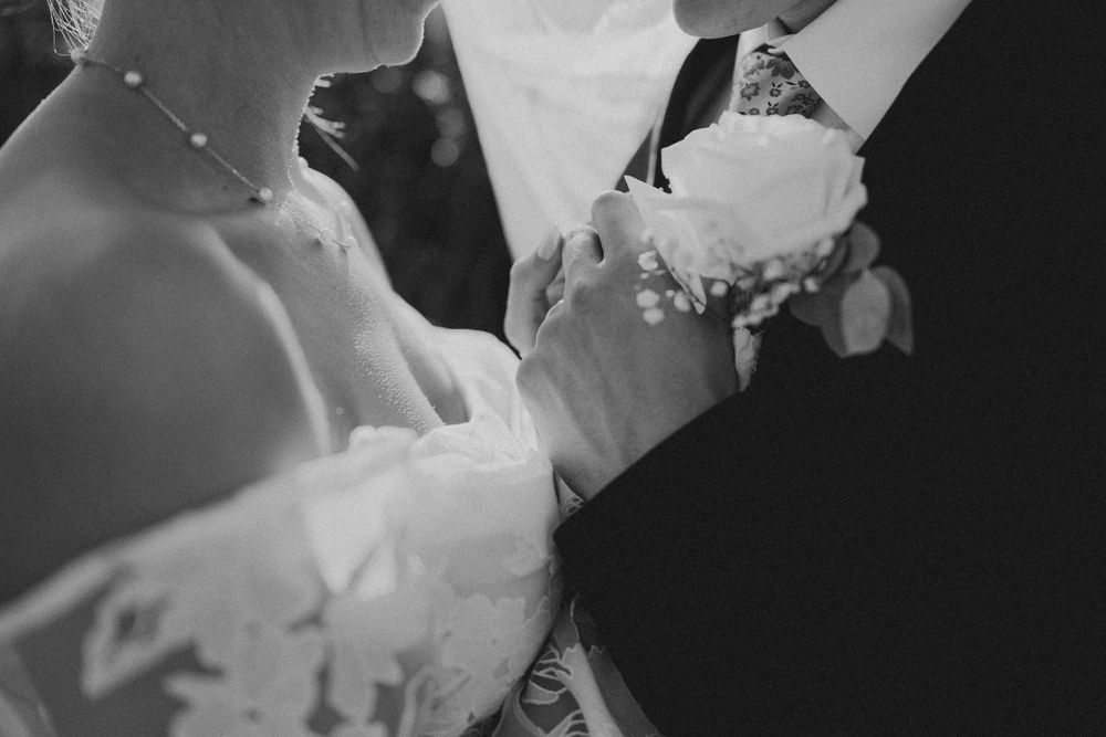 Black and white close-up detail of couple's formal wedding attire.