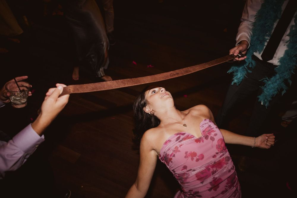 People dancing and spinning on a dark dance floor at a celebration.
