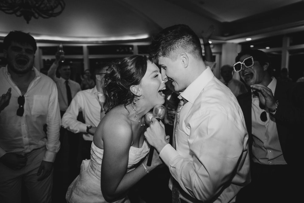Party guests dancing in close proximity under dramatic black and white lighting.