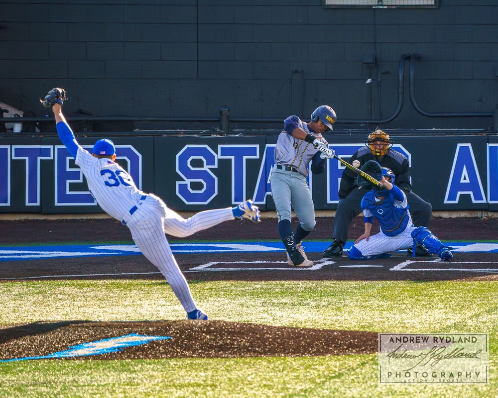 Baseball players in dramatic stretch play at first base during competitive game.