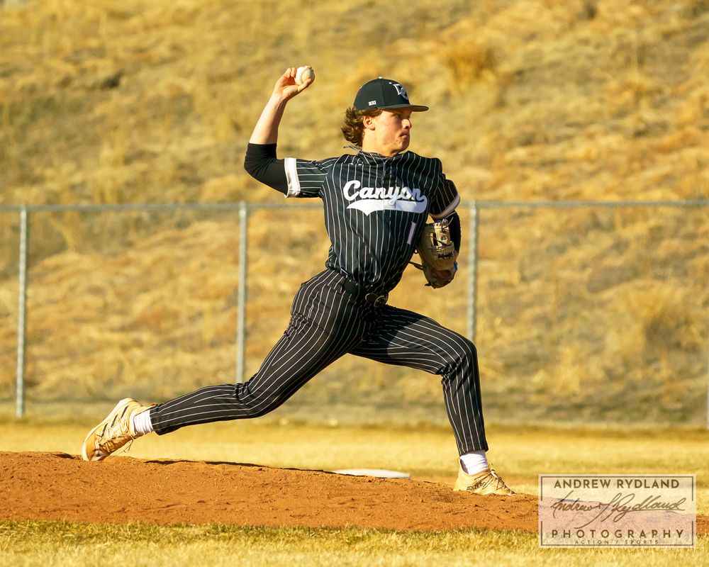 Baseball pitcher in pinstripe uniform throws a powerful pitch from the mound during a game.