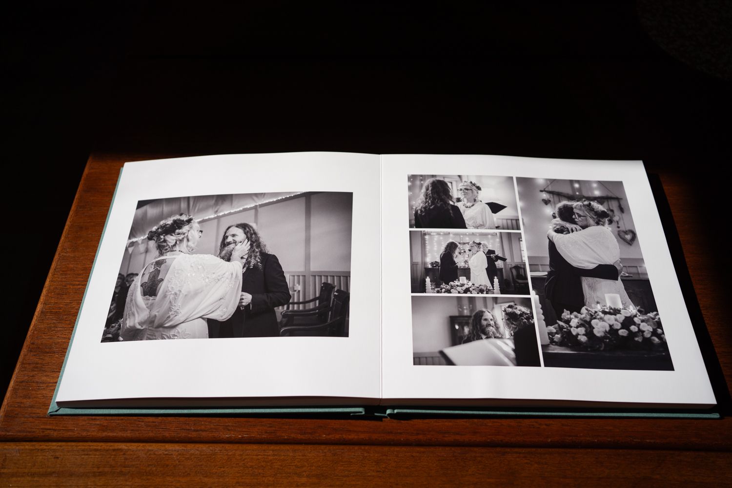 Open wedding photo album showing black and white candid moments across multiple pages.