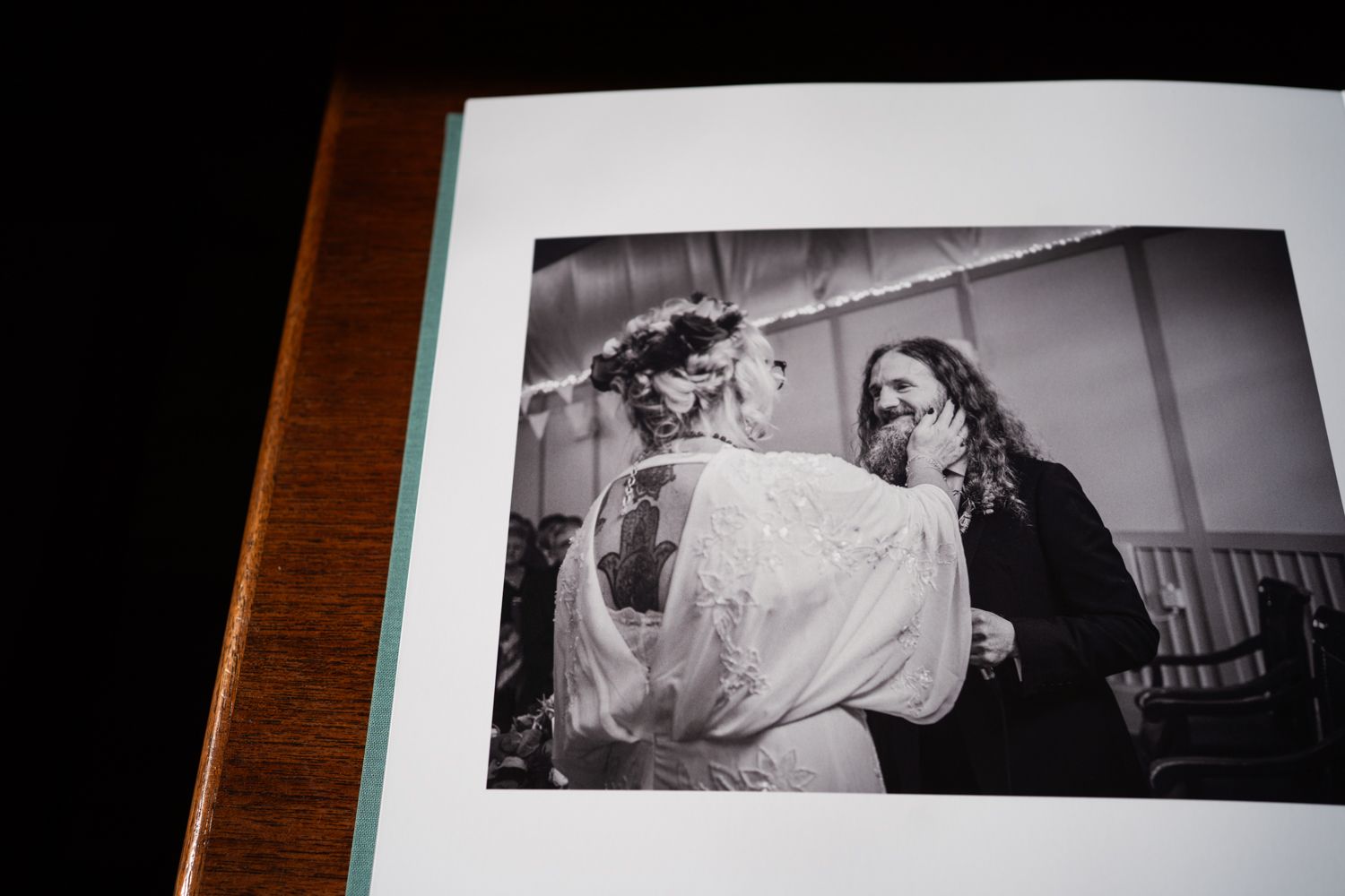 Black and white intimate moment captured in a photo album showing a tender wedding dance between two people.