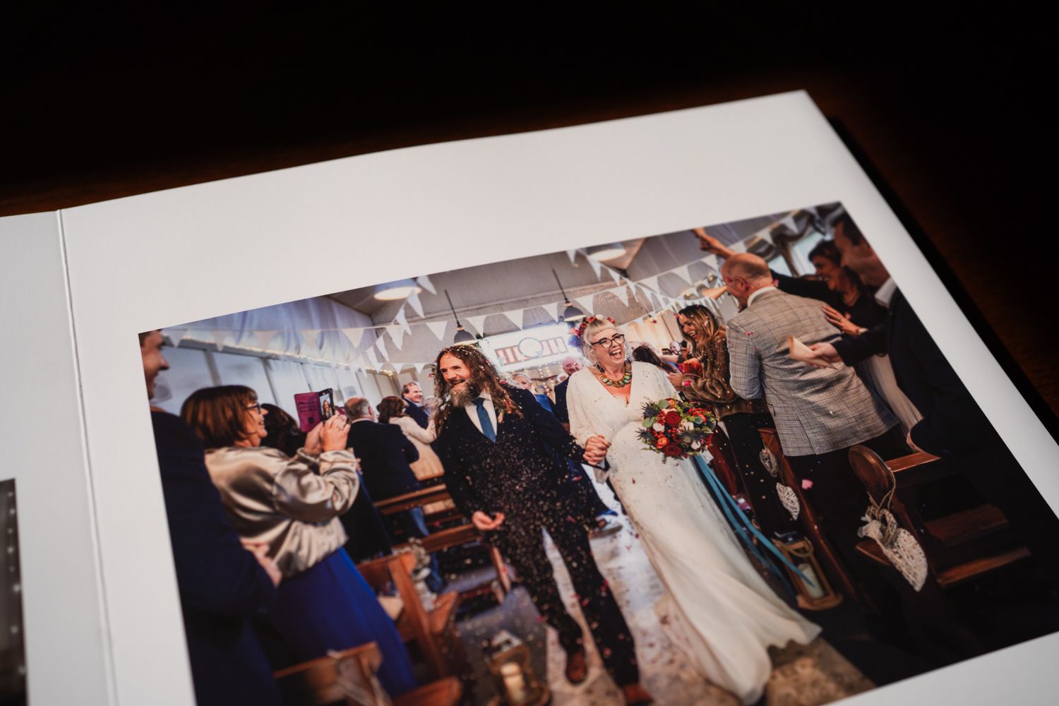 A wedding celebration scene with guests applauding and celebrating during an indoor reception.