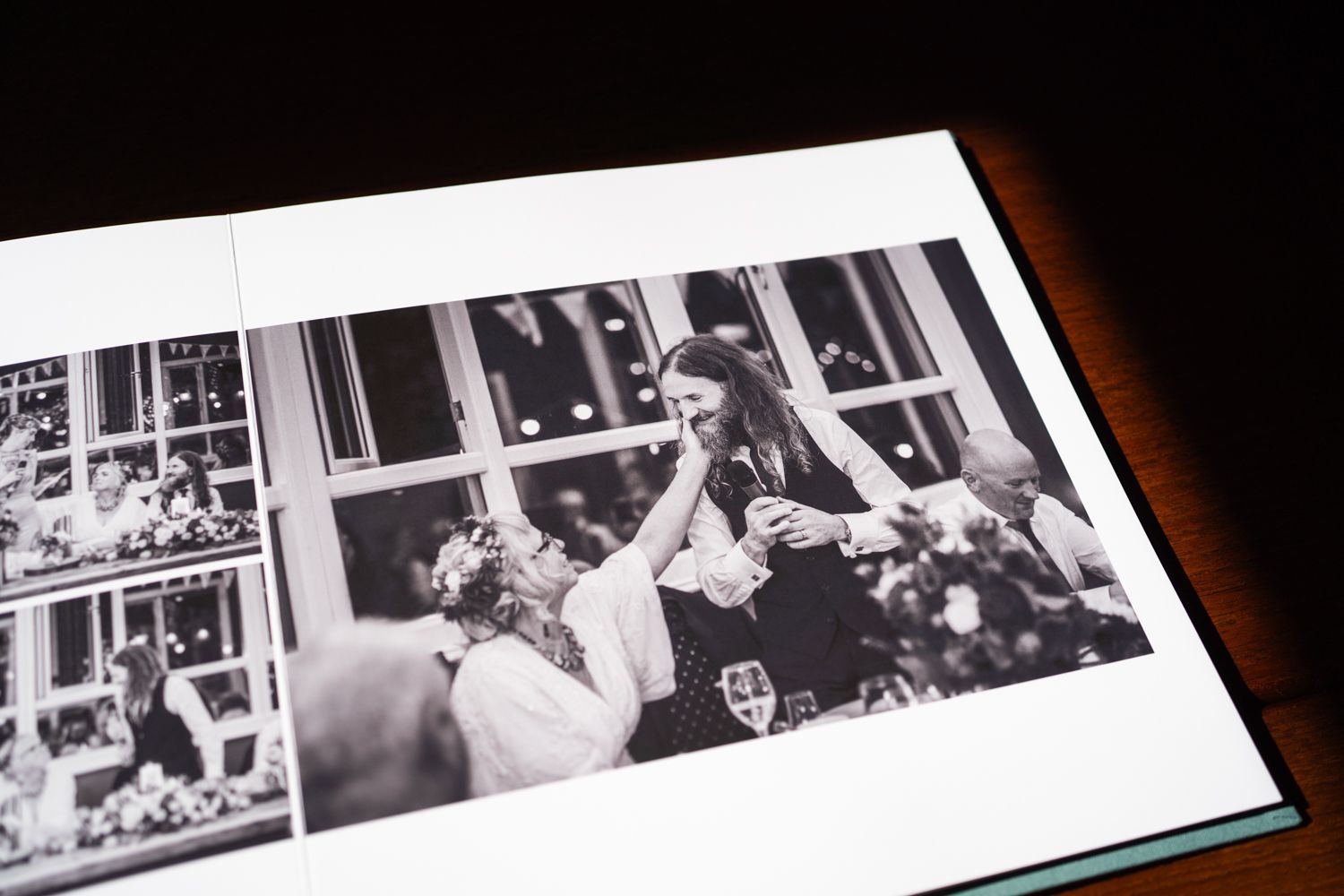 Black and white wedding photo printed in a photo album showing a tender moment between a couple.