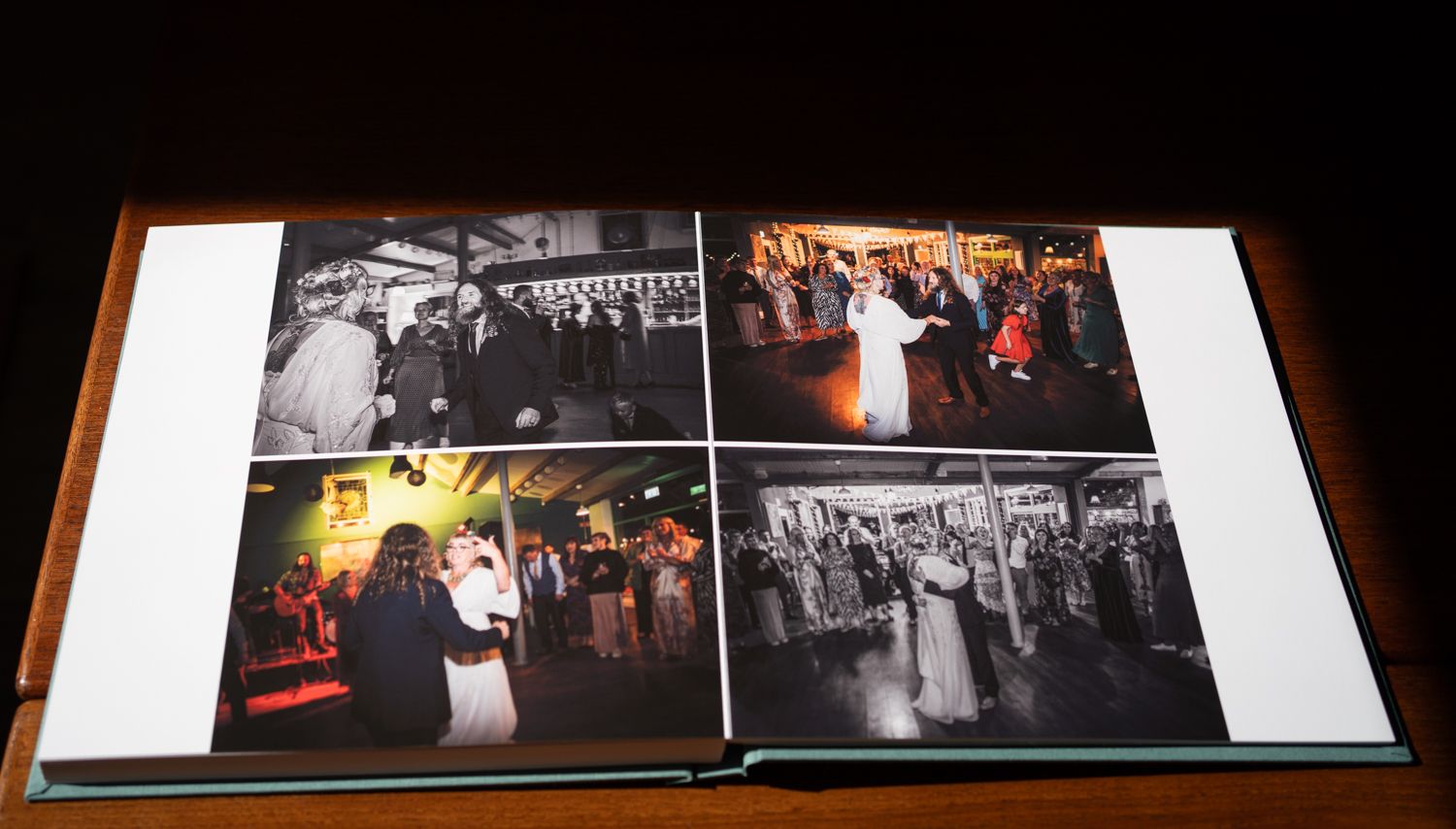 A wedding photo album shows four black and white and color reception dance photos arranged on an open page spread.