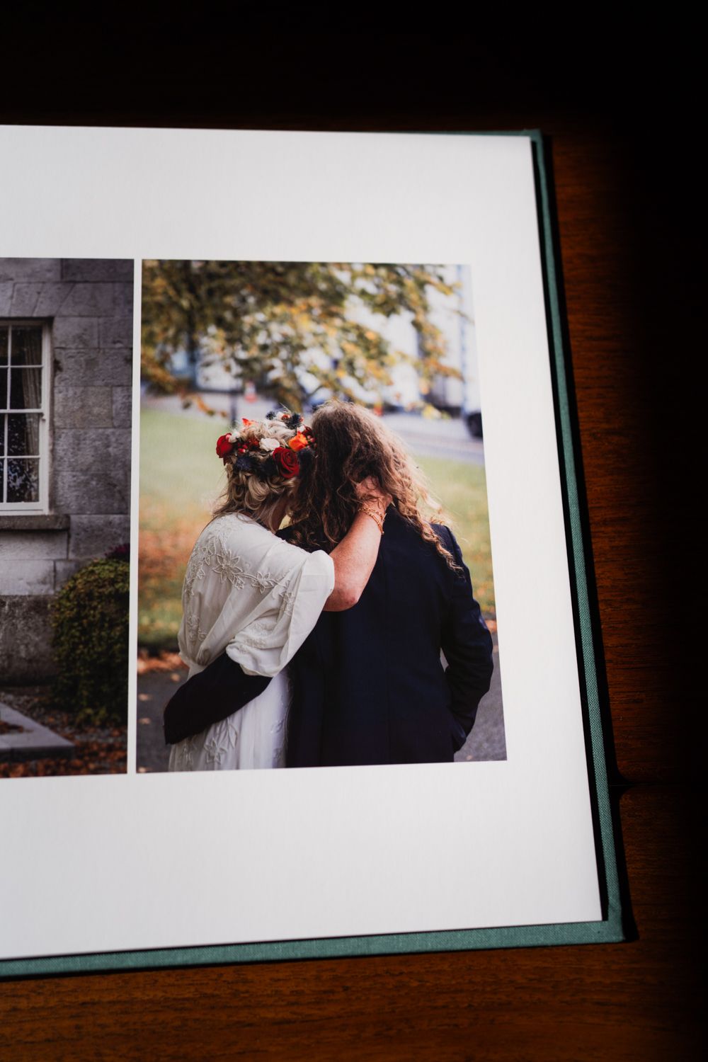 Wedding photo album showing a romantic moment outdoors with autumn colors in the background.