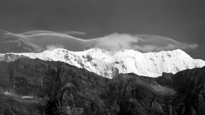 Monochrome landscape of jagged mountain peaks with snow-covered summits.